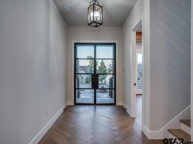 doorway featuring dark parquet floors and a chandelier