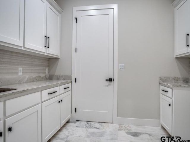 kitchen with white cabinets and light stone counters