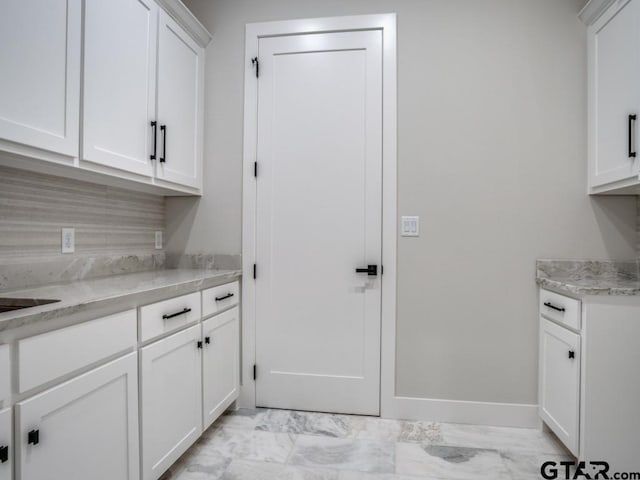 2424 Bellview Cir, Tyler, TX 75709 - kitchen featuring light marble finish floors, white cabinets, light countertops, and decorative backsplash