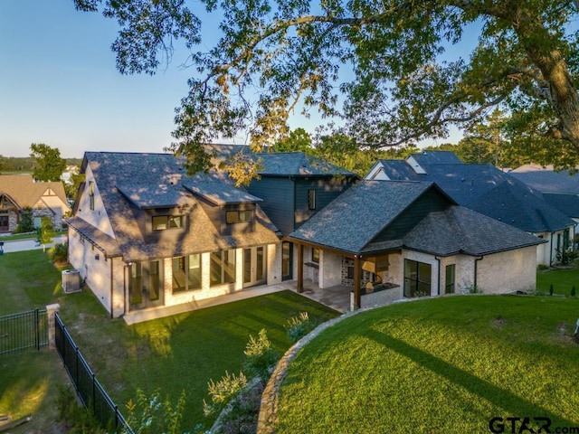 2424 Bellview Cir, Tyler, TX 75709 - back of property featuring a fenced backyard, a patio area, and stone siding