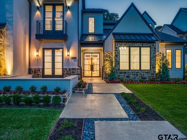 property entrance with a yard, french doors, and a balcony