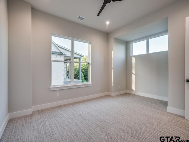 spare room with light colored carpet and ceiling fan