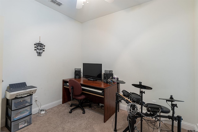 carpeted home office featuring ceiling fan