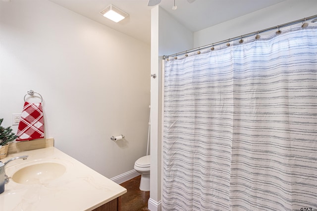 bathroom featuring walk in shower, vanity, and toilet