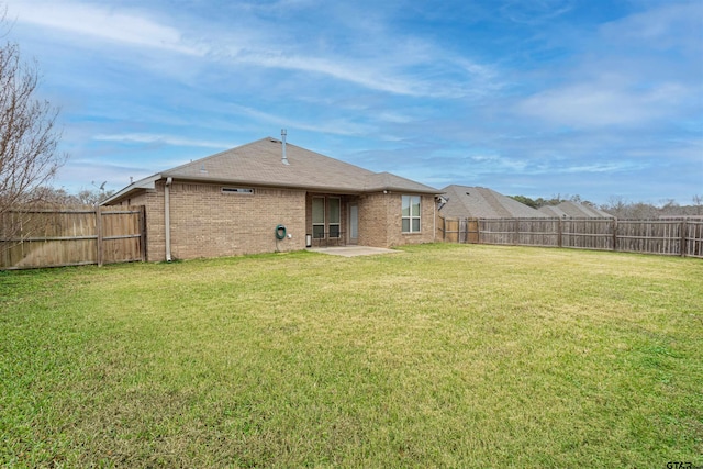 rear view of house featuring a lawn and a patio area