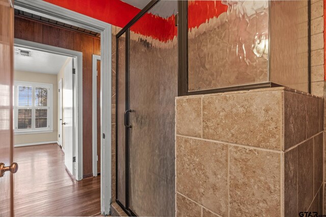 bathroom with hardwood / wood-style floors and a shower with door