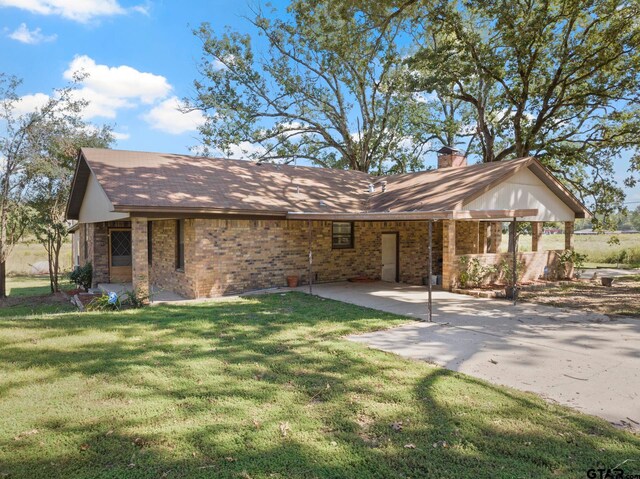 ranch-style home with a front yard and a patio