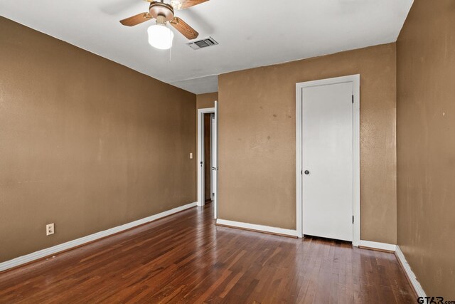 spare room with ceiling fan and dark hardwood / wood-style flooring