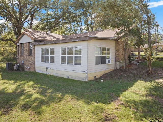 view of side of property featuring central air condition unit, cooling unit, and a lawn