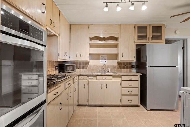 kitchen with sink, ceiling fan, backsplash, light brown cabinets, and appliances with stainless steel finishes