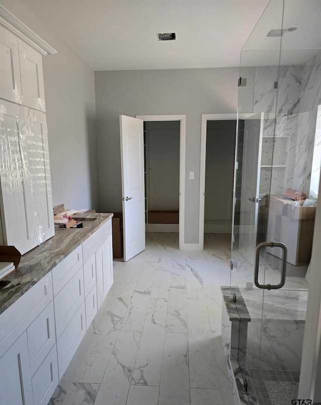 full bath with marble finish floor and a marble finish shower