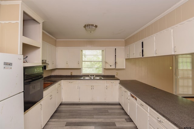 kitchen with white cabinets, ornamental molding, dark hardwood / wood-style floors, white fridge, and black oven