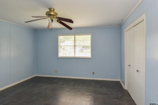 unfurnished bedroom featuring wood walls, a closet, ceiling fan, and crown molding