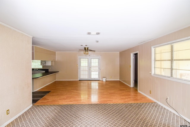 unfurnished living room featuring ceiling fan, crown molding, and light hardwood / wood-style flooring