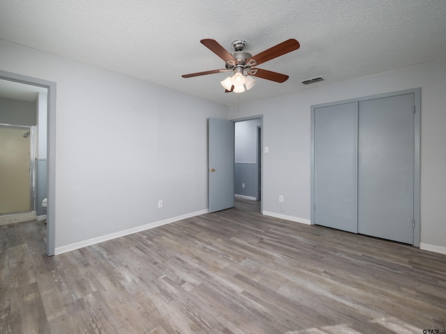 unfurnished bedroom with ceiling fan, light hardwood / wood-style floors, a textured ceiling, and a closet