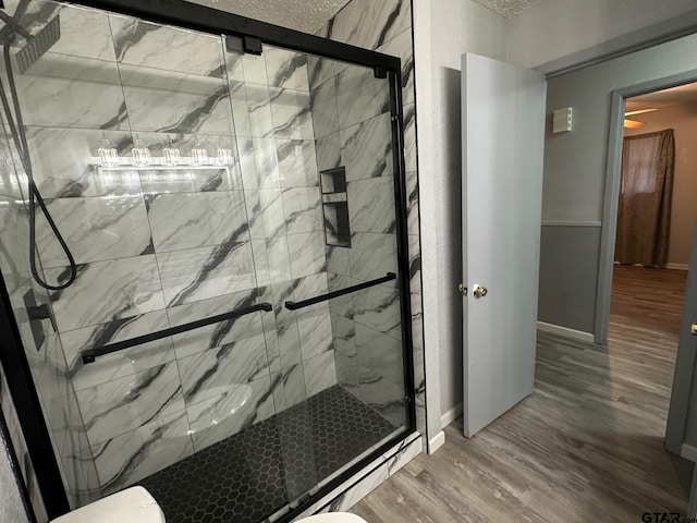 bathroom with wood-type flooring, toilet, and walk in shower