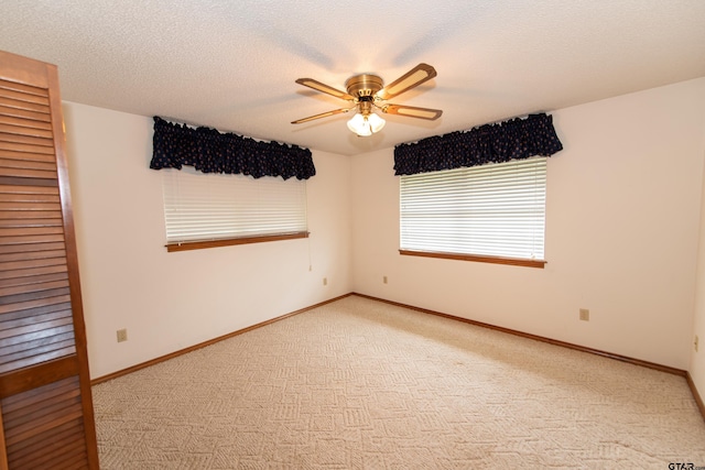 unfurnished room featuring ceiling fan, a textured ceiling, and light carpet