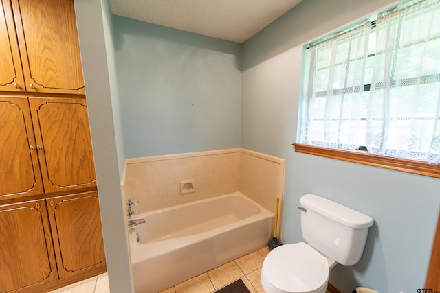 bathroom featuring toilet, a washtub, a textured ceiling, and tile patterned flooring