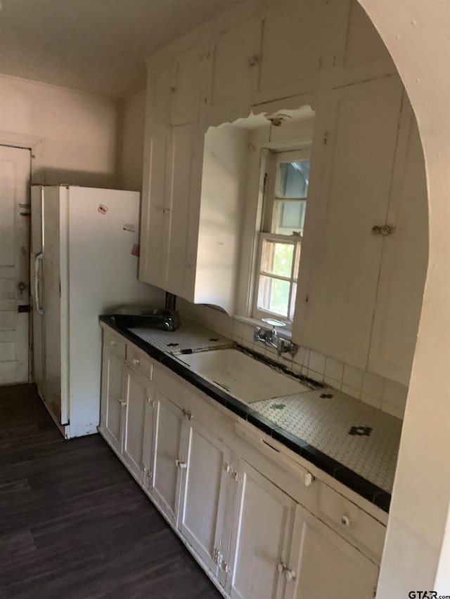 kitchen featuring white cabinetry, dark hardwood / wood-style flooring, sink, and white refrigerator