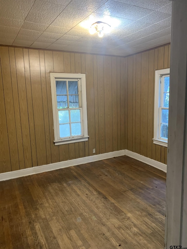 920 N Spring Ave, Tyler, TX 75702 - unfurnished room featuring hardwood / wood-style floors, healthy amount of natural light, and wooden walls