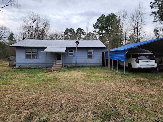 view of front of property with entry steps, metal roof, and a front lawn