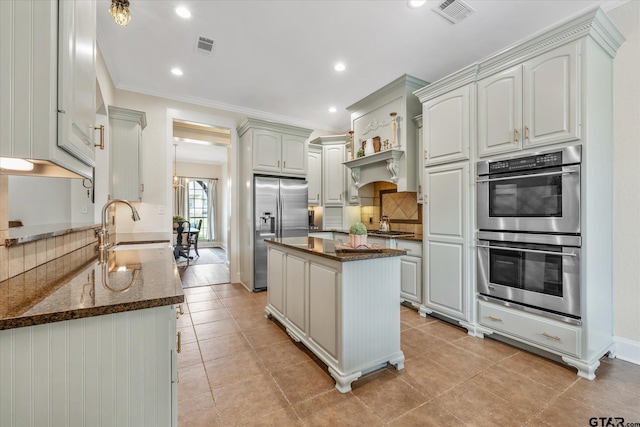 523 Southcreek Dr, Chandler, TX 75758 - kitchen with stainless steel appliances, decorative backsplash, dark stone countertops, a sink, and ornamental molding