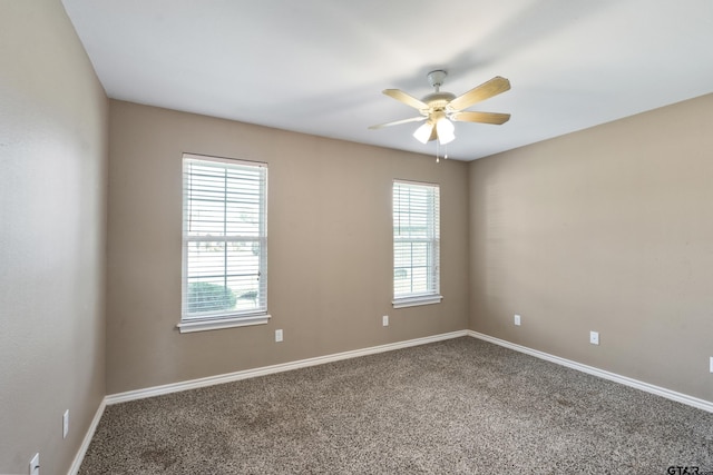 carpeted spare room featuring a wealth of natural light and ceiling fan