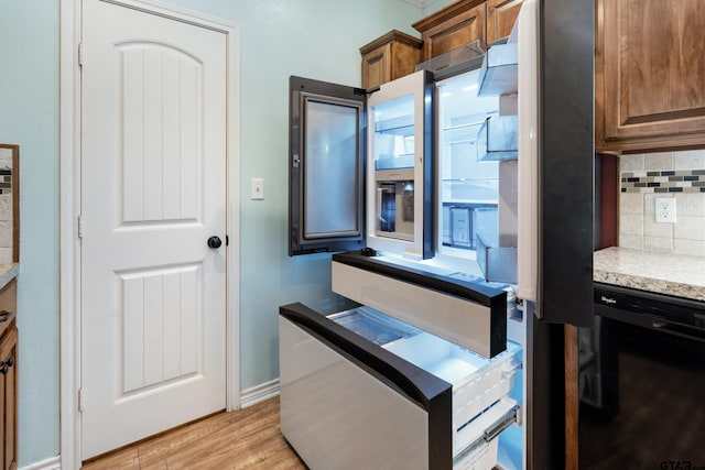 kitchen with black dishwasher, light hardwood / wood-style flooring, and backsplash