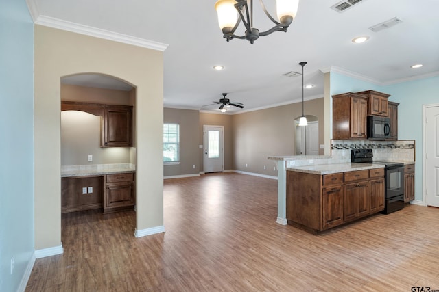 kitchen with black appliances, hanging light fixtures, hardwood / wood-style floors, kitchen peninsula, and ceiling fan with notable chandelier