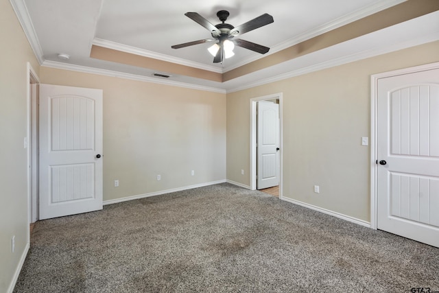 interior space featuring carpet flooring, ceiling fan, crown molding, and a tray ceiling