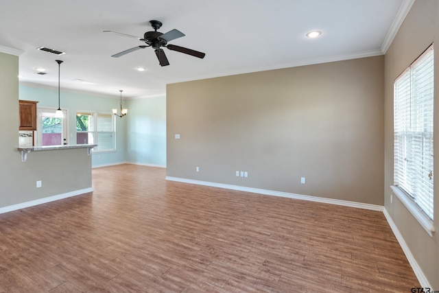 unfurnished living room featuring light hardwood / wood-style floors, ceiling fan with notable chandelier, and ornamental molding