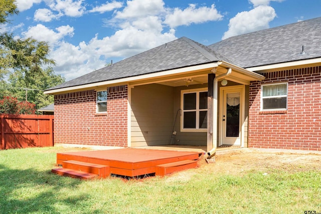 back of house with a deck, a lawn, and ceiling fan