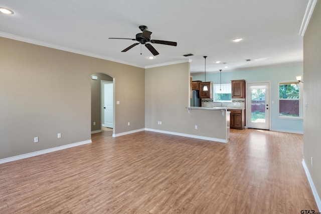 unfurnished living room featuring light hardwood / wood-style floors, ceiling fan, crown molding, and sink