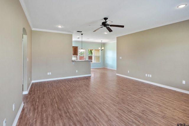 unfurnished living room with light wood-type flooring, ceiling fan with notable chandelier, and crown molding