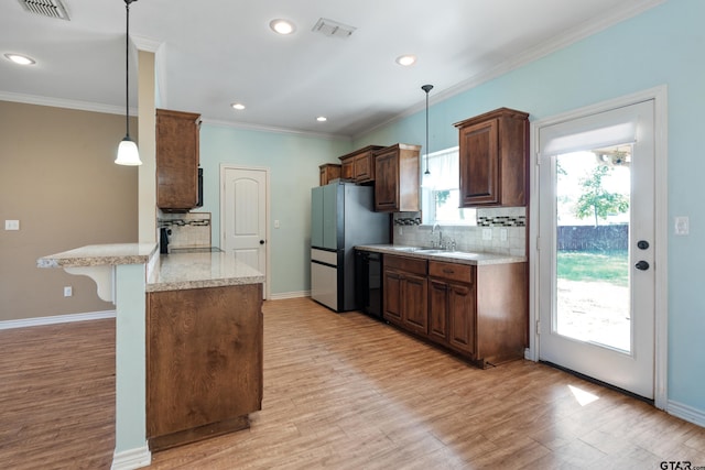 106 Bristol Cir, Chandler, TX 75758 - kitchen with a peninsula, decorative backsplash, freestanding refrigerator, light wood-style floors, and crown molding
