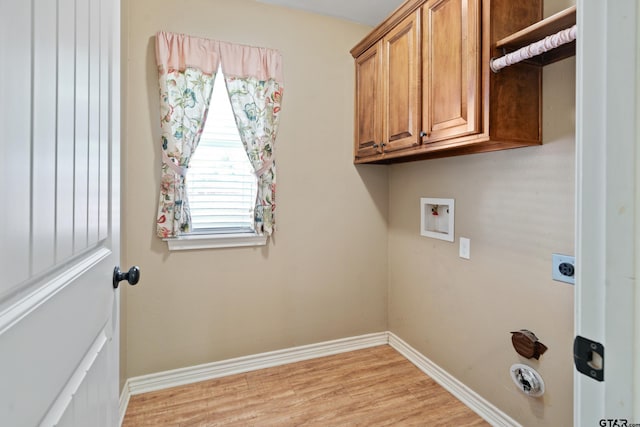 washroom with washer hookup, electric dryer hookup, light hardwood / wood-style floors, and cabinets