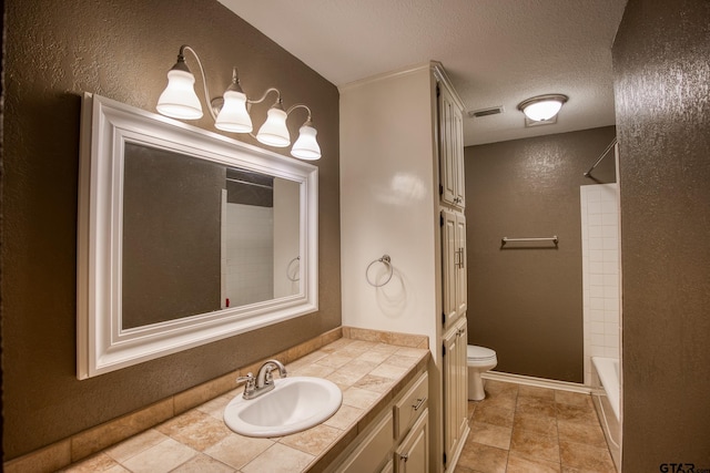 full bathroom featuring vanity, a textured ceiling, toilet, and washtub / shower combination