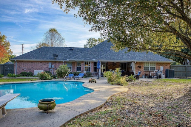 view of pool with a diving board, central air condition unit, and a patio