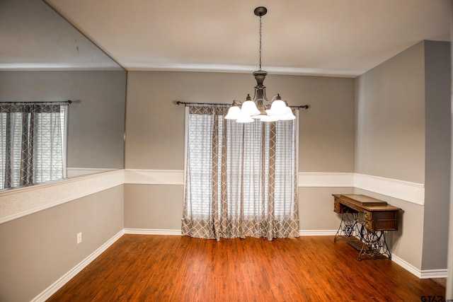 unfurnished dining area featuring hardwood / wood-style floors, plenty of natural light, and a notable chandelier