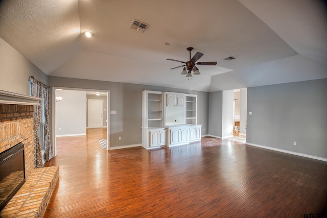 unfurnished living room with a textured ceiling, ceiling fan, wood-type flooring, a fireplace, and lofted ceiling