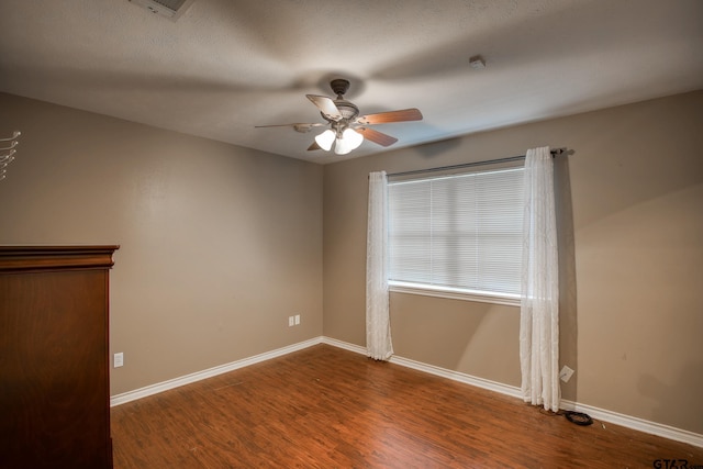 empty room featuring a textured ceiling, dark hardwood / wood-style flooring, and ceiling fan