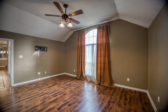 bonus room featuring ceiling fan with notable chandelier, dark wood-type flooring, and lofted ceiling