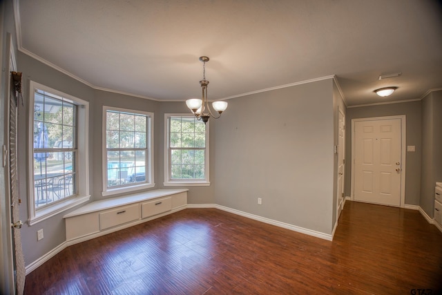 spare room with dark hardwood / wood-style flooring, crown molding, and an inviting chandelier