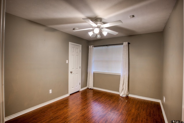 unfurnished room with ceiling fan and dark hardwood / wood-style floors