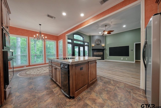 3606 Brookview Ct, Tyler, TX 75707 - kitchen featuring black appliances, a fireplace, healthy amount of natural light, a chandelier, and crown molding