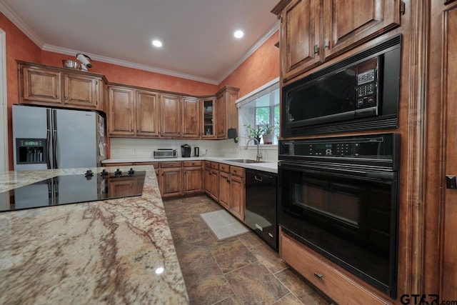 3606 Brookview Ct, Tyler, TX 75707 - kitchen featuring black appliances, ornamental molding, brown cabinetry, light stone countertops, and glass insert cabinets