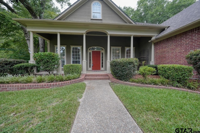 3606 Brookview Ct, Tyler, TX 75707 - view of front of house with a front yard, covered porch, and brick siding