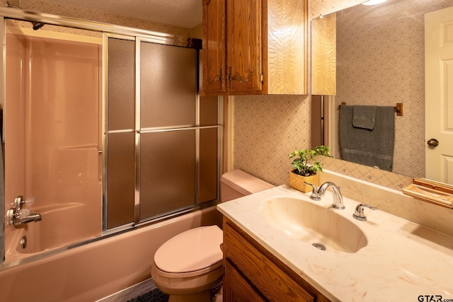 full bathroom featuring vanity, shower / bath combination with glass door, and toilet