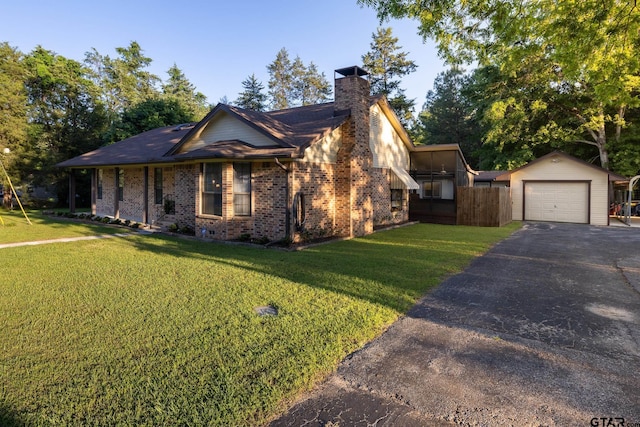 view of front of property with a garage, an outbuilding, and a front yard