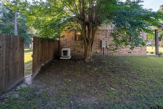 view of side of property featuring ac unit and a yard